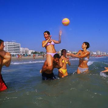 People playing volleyball in the sea.
