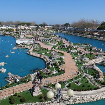 Parco in miniatura con modelli dettagliati e laghi, atmosfera serena e affascinante.
