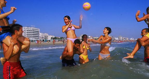 People playing volleyball in the sea.