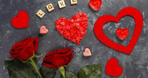 Cœurs rouges, roses et 'LOVE' sur fond gris.