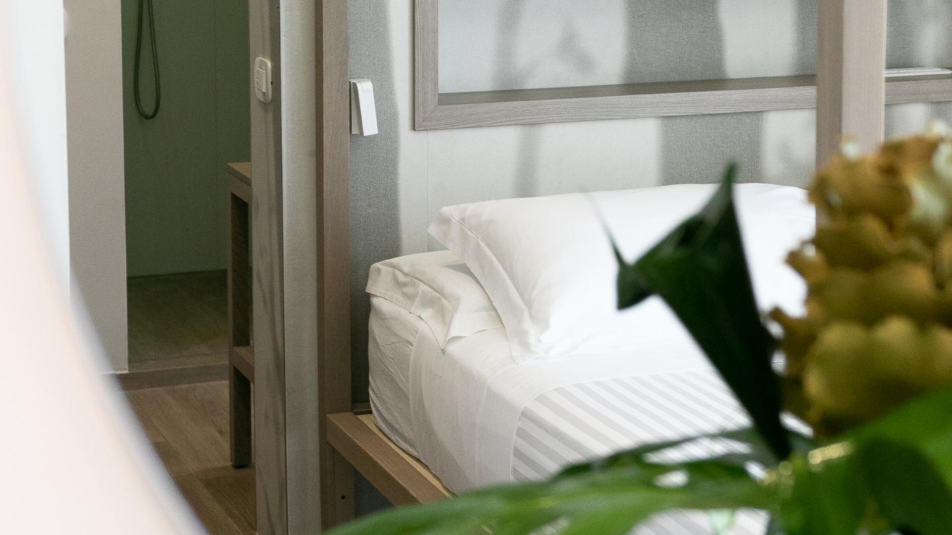 Camera accogliente con letto ordinato, atmosfera serena e dettagli naturali.