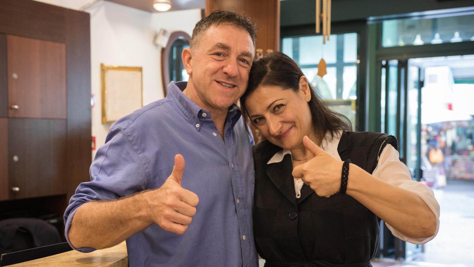 Due persone sorridenti mostrano pollici in su, trasmettono felicità e complicità.