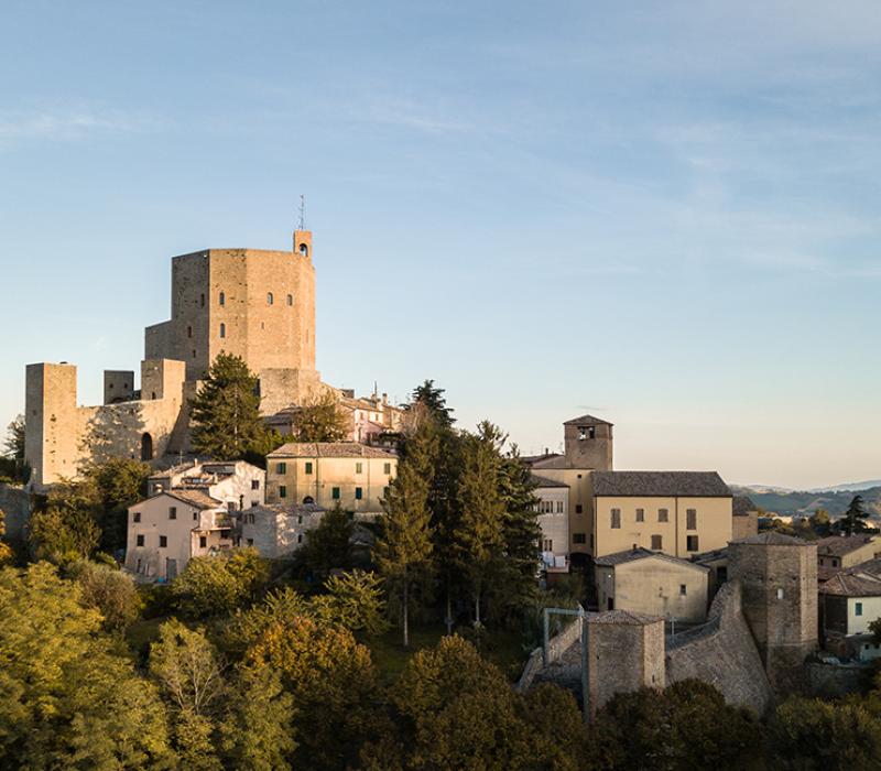 Castello illuminato di notte, con luna piena nel cielo blu scuro, atmosfera magica e serena.